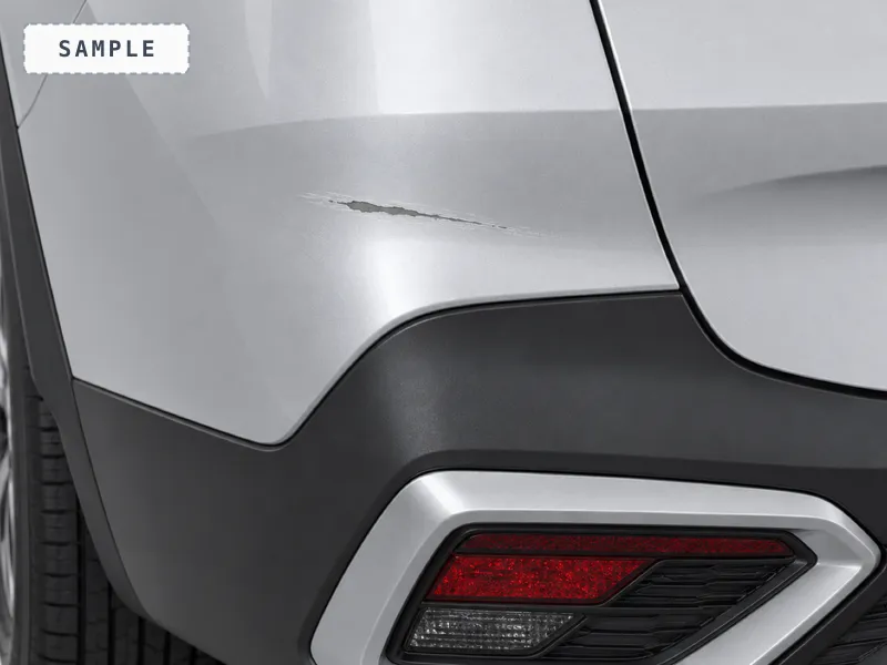 A scratch through the paint on the rear bumper corner
